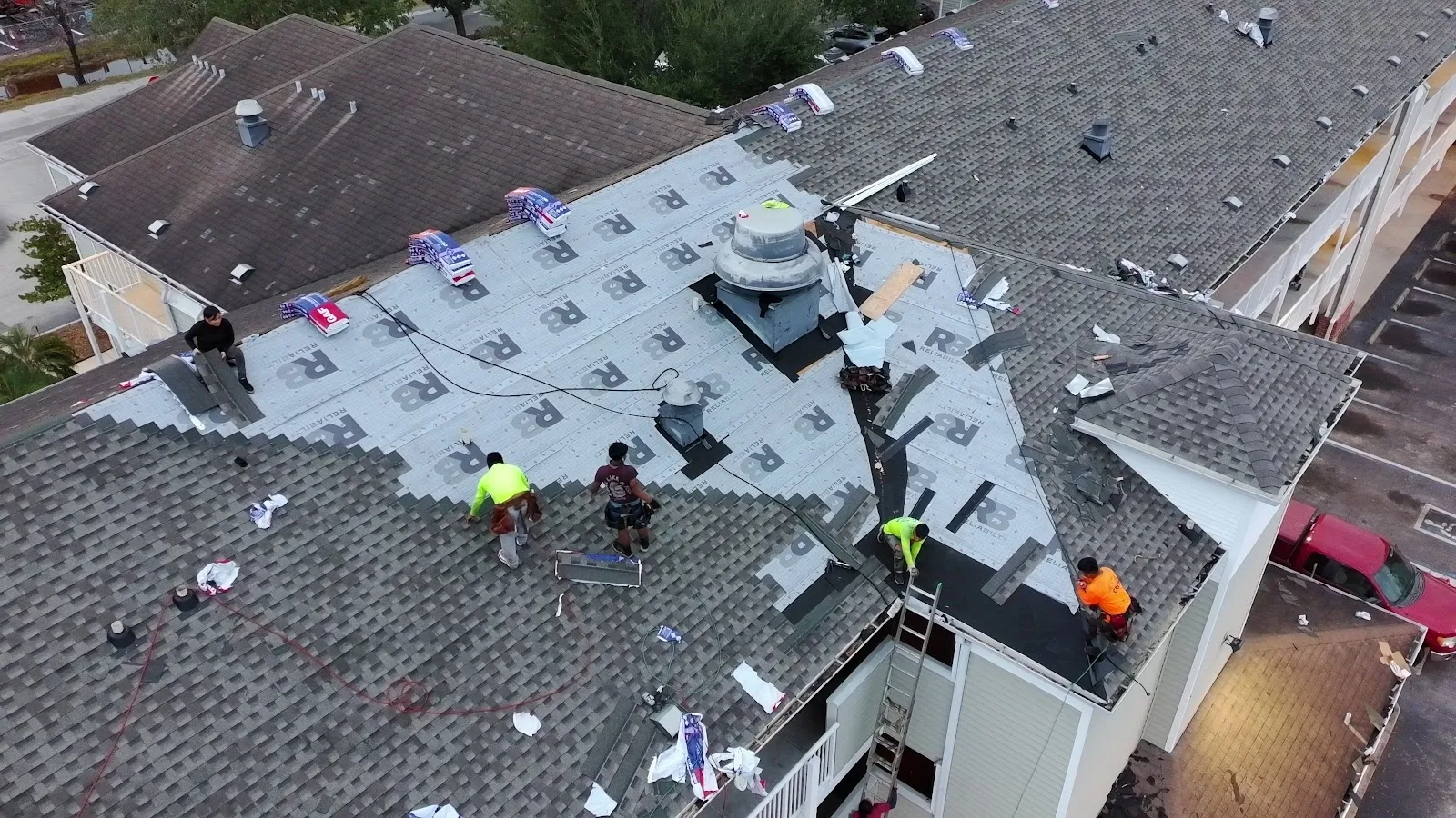 AVB Construction crew replacing roof decking and shingles on a multi-family building