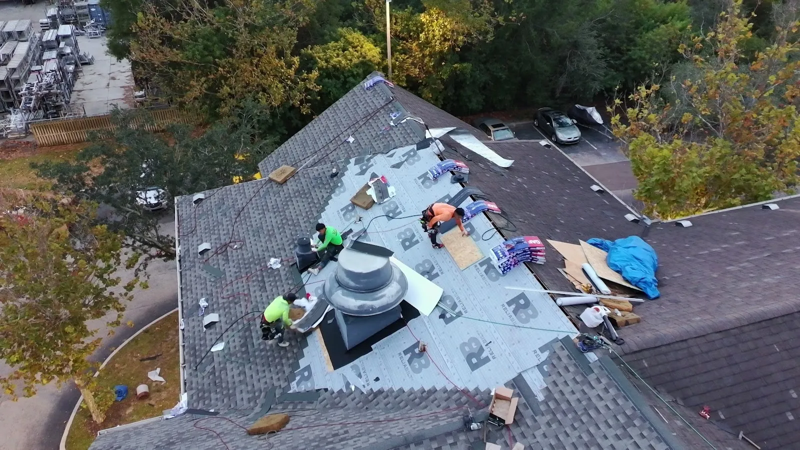 Emergency roof repair in progress with damaged area opened up and protected by AVB Construction